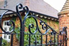 Wrought iron gates closeup, closed black metal gates to a country manor house, UK